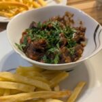 Eine Schüssel Carbonade à la flamande mit Pommes frites
